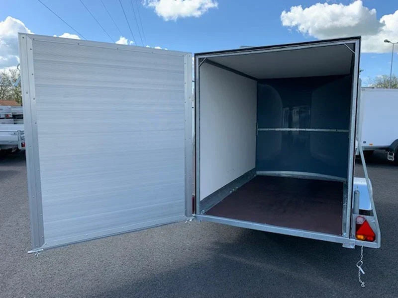 Reboque de baú Debon Cargo 1300 novo, em poliéster azul, com porta lateral.