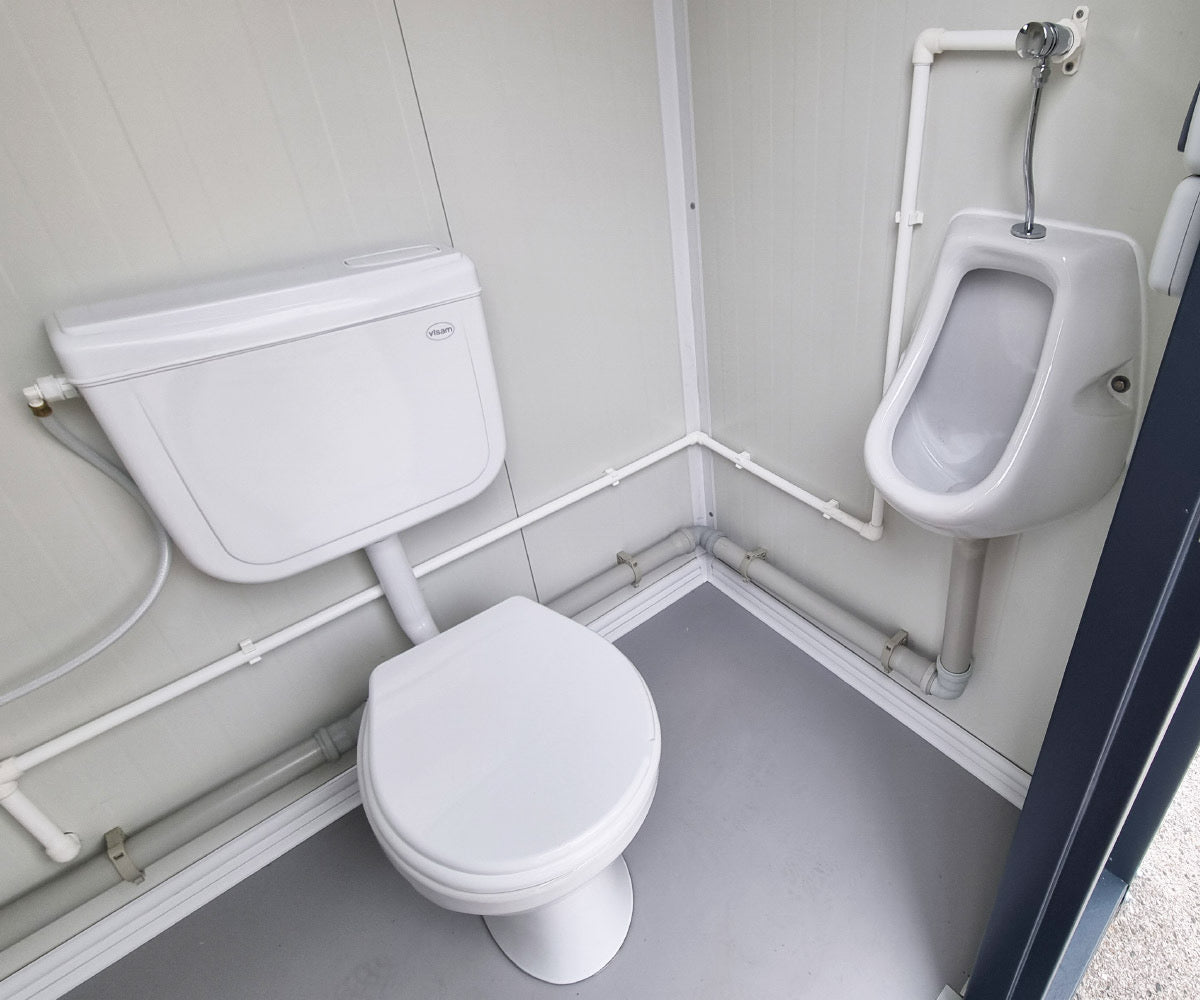 Contentor sanitário novo de formato compacto, equipado com sanita, urinol e lavatório.